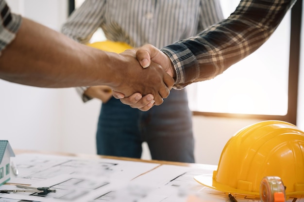 Trabajador de la construcción y contratista Cliente estrechando la mano con el constructor del equipo en la oficina por la mañana