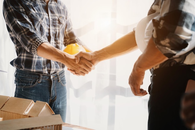 Trabajador de la construcción y contratista Cliente estrechando la mano con el constructor del equipo en el sitio de renovación por la mañana