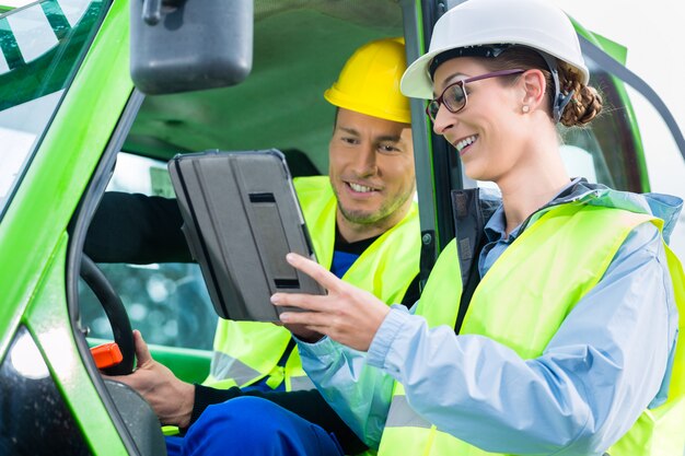 Trabajador de la construcción discutiendo con planos de ingeniero