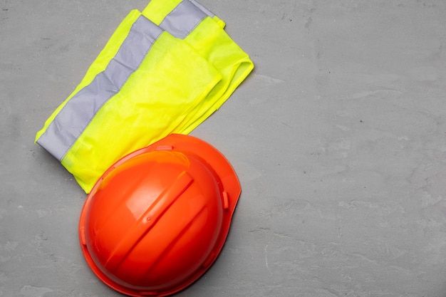 Trabajador de la construcción establece casco y chaleco fluorescente vista superior