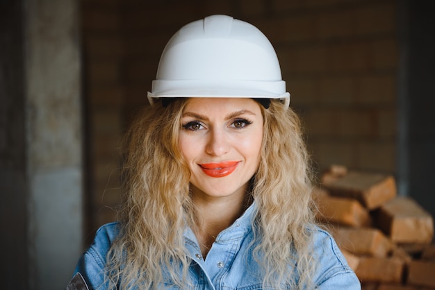 Trabajador de la construcción femenina atractiva en casco