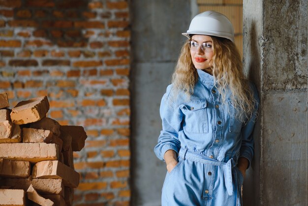 Trabajador de la construcción femenina atractiva en casco