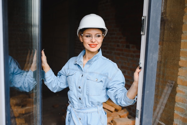 Trabajador de la construcción femenina atractiva en casco