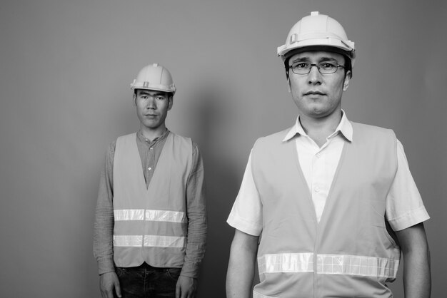 Trabajador de la construcción de hombres asiáticos juntos aislado