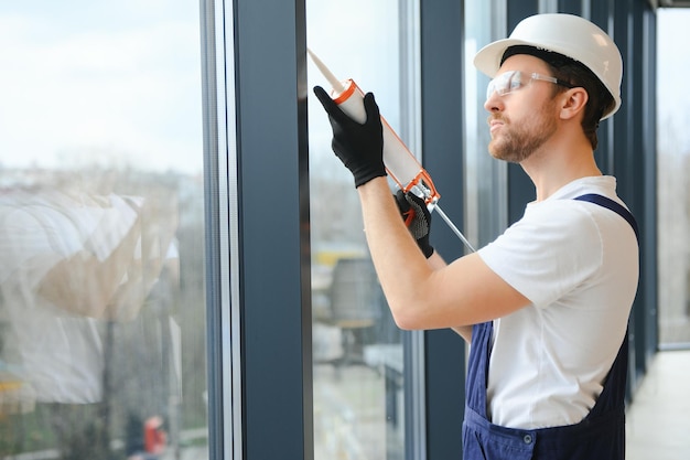 Trabajador de la construcción instalando ventana en casa