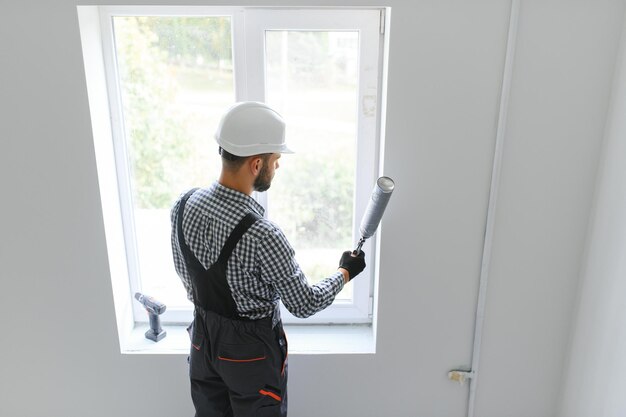 Trabajador de la construcción instalando una ventana en casa
