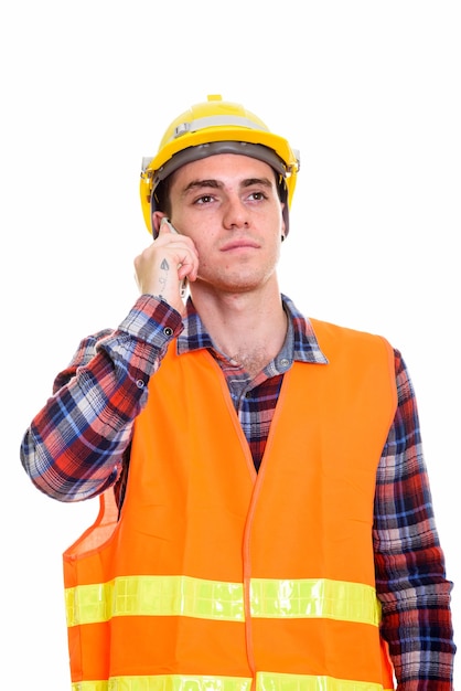 Trabajador de la construcción joven pensando mientras habla por teléfono