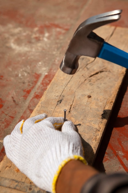 Foto trabajador de la construcción con martillo en el lugar de trabajo