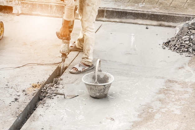 Trabajador de la construcción con martillo neumático de perforación de superficie de hormigón