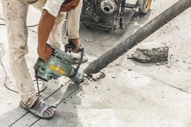 Trabajador de la construcción con martillo perforador de superficie de hormigón