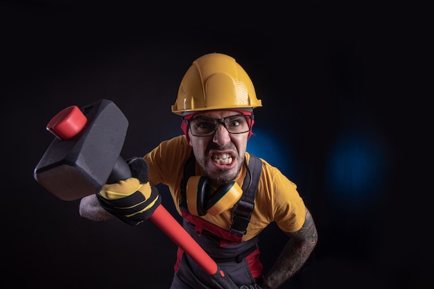 El trabajador de la construcción masculino con un mazo