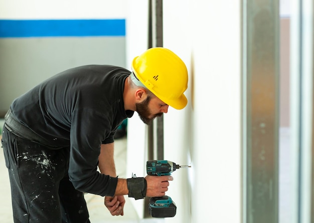 Foto trabajador de la construcción perforando la pared