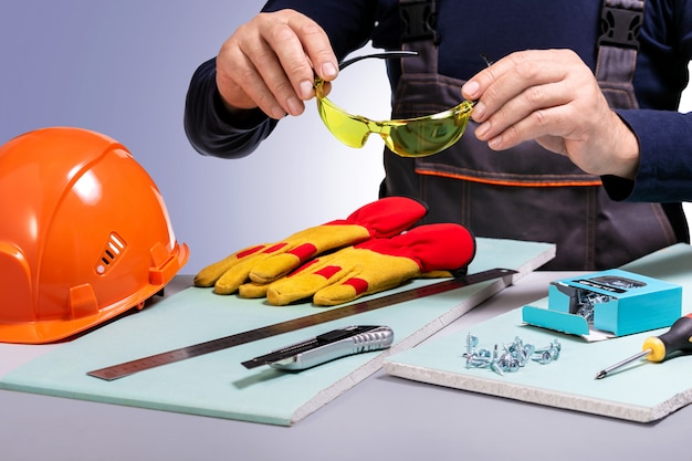 Foto trabajador de la construcción poniéndose gafas protectoras. concepto de equipo de seguridad.