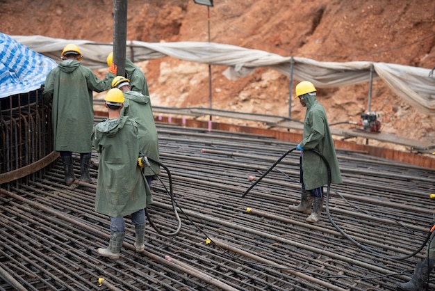 Trabajador de la construcción que vierte un hormigón en la fundación de masas