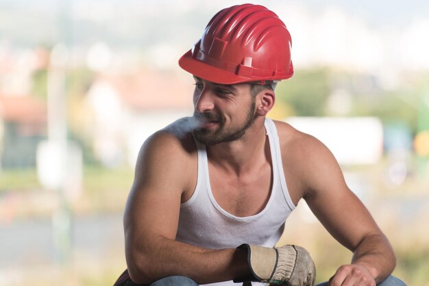 Trabajador De La Construcción Relajando El Aire Fresco Durante El Trabajo