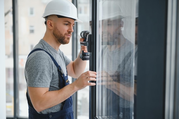 Trabajador de la construcción reparando una ventana de plástico con un destornillador en el interior, espacio para texto. Diseño de pancartas