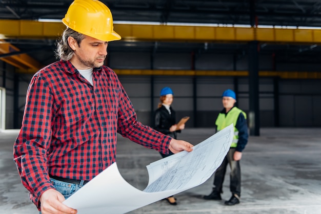 Trabajador de la construcción revisando planos