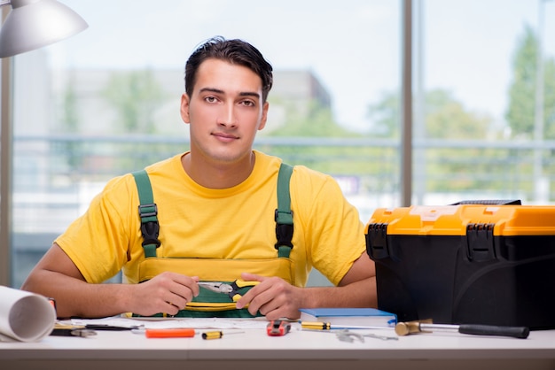 Trabajador de la construcción sentado en el escritorio