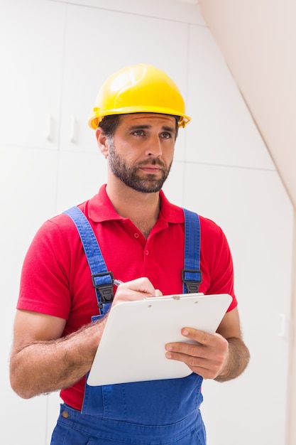 Foto trabajador de la construcción tomando notas en el portapapeles