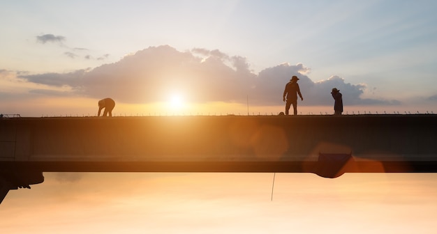 Trabajador de la construcción trabajando con puesta de sol