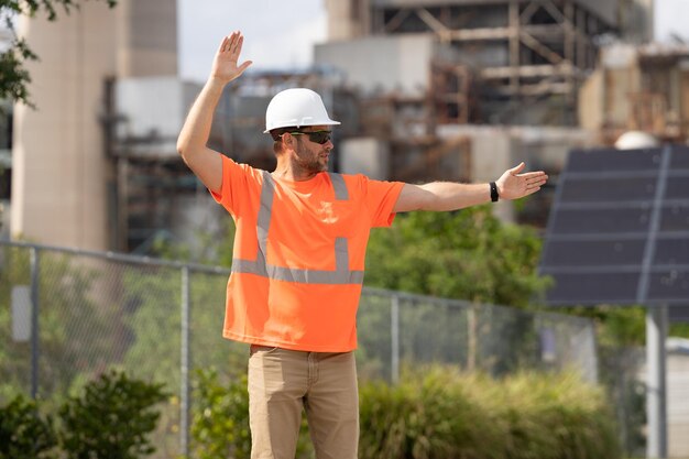 Foto trabajador de la construcción en el trabajo hombre vestido con casco y chaleco de seguridad en el sitio de construcción