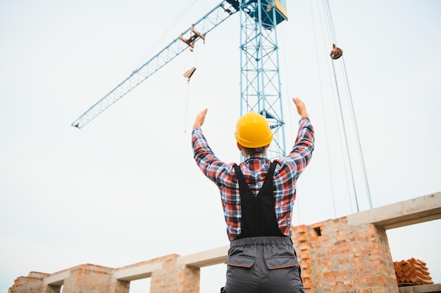 Trabajador de la construcción con uniforme y equipo de seguridad tiene trabajo en la construcción de un tema industrial