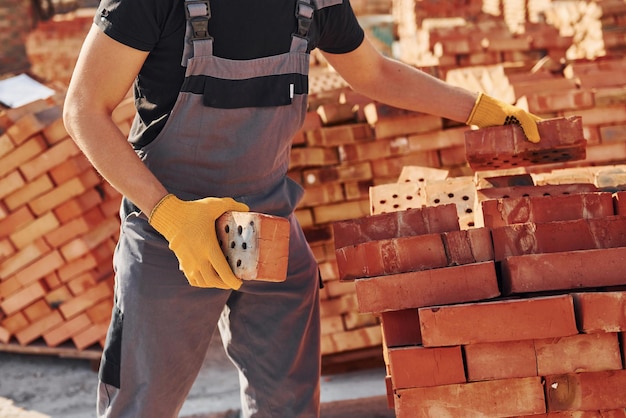 Trabajador de la construcción en uniforme y equipo de seguridad tiene trabajo en la construcción