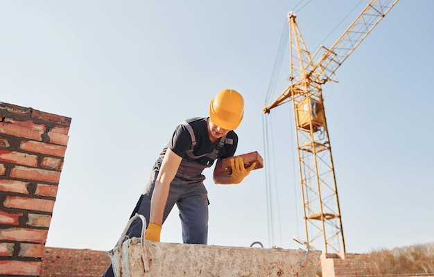 Trabajador de la construcción en uniforme y equipo de seguridad tiene trabajo en la construcción