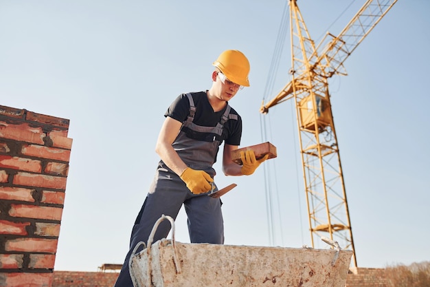 Trabajador de la construcción en uniforme y equipo de seguridad tiene trabajo en la construcción