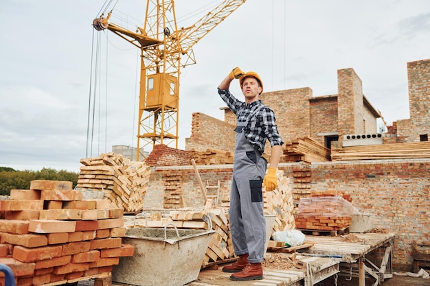 Trabajador de la construcción en uniforme y equipo de seguridad tiene trabajo en la construcción