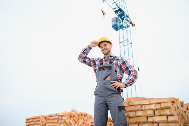 Trabajador de la construcción en uniforme y equipo de seguridad tiene trabajo en la construcción