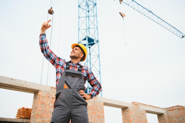 Trabajador de la construcción en uniforme y equipo de seguridad tiene trabajo en la construcción