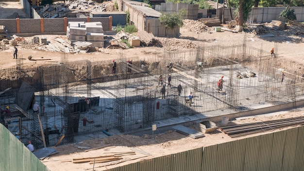 Foto trabajador y constructor en el sitio de construcción fundación terminada de un edificio en construcción