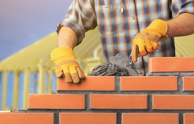 Trabajador construye una pared de ladrillos en la casa