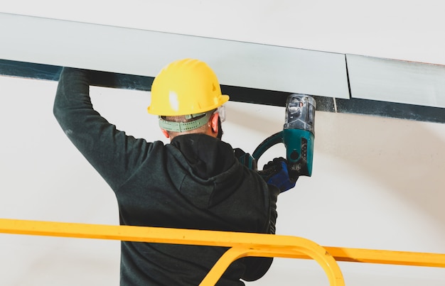 Trabajador construye una pared de placas de yeso.