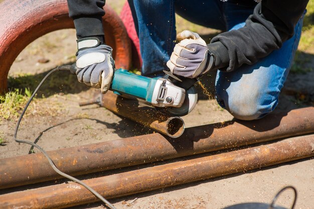 Trabajador corta un tubo de metal