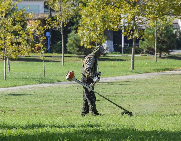 Trabajador cortando el césped Cortando el cortacésped