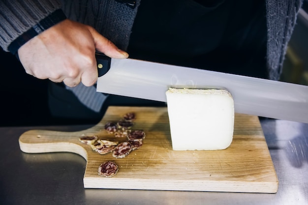 Foto trabajador cortando el queso