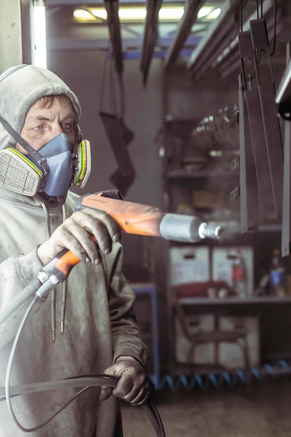 Trabajador cuelga piezas antes de pintar en una fábrica.