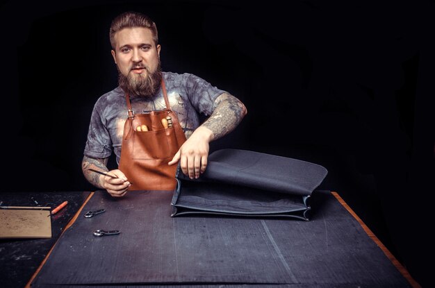 Trabajador de cuero que produce piezas de cuero./Leather Currier realiza trabajos de cuero para un nuevo producto en su estudio.