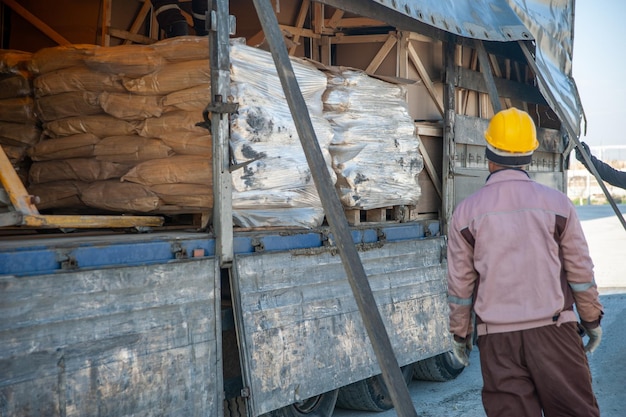 Un trabajador descarga un camión en una construcción industrial.