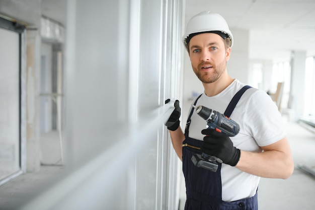 Trabajador de drywall trabaja en un sitio de construcción en una casa