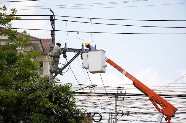 Trabajador electricista de la Autoridad Metropolitana de Electricidad que trabaja en la reparación del sistema eléctrico en el pilar de la electricidad o en el poste de servicios públicos el 21 de abril de 2018 en Bangkok, Tailandia