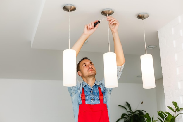 Foto trabajador electricista instalando lámpara de techo