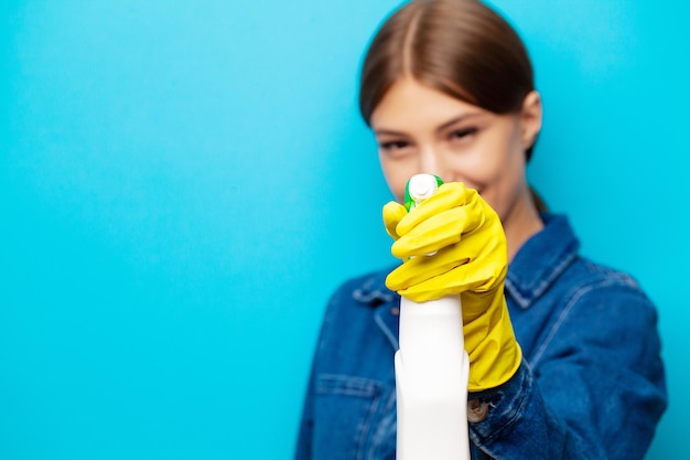 Trabajador de la empresa de limpieza en overoles, guantes amarillos y artículos de limpieza.