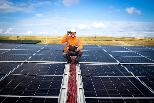 Trabajador de energía solar comprobando la instalación y la productividad de una nueva planta de energía solar