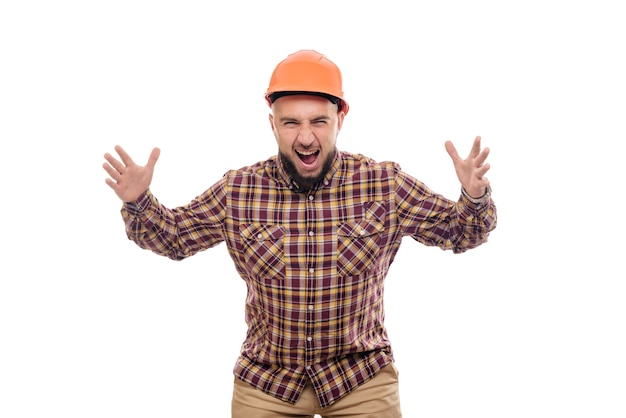 Foto un trabajador enojado y nervioso con un casco naranja está hablando en voz alta por teléfono, gritando en el teléfono. fondo blanco aislado