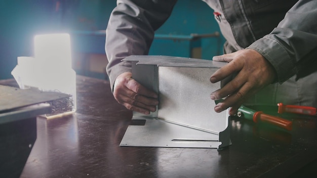 Trabajador ensamblando la pieza metálica en el concepto industrial manual