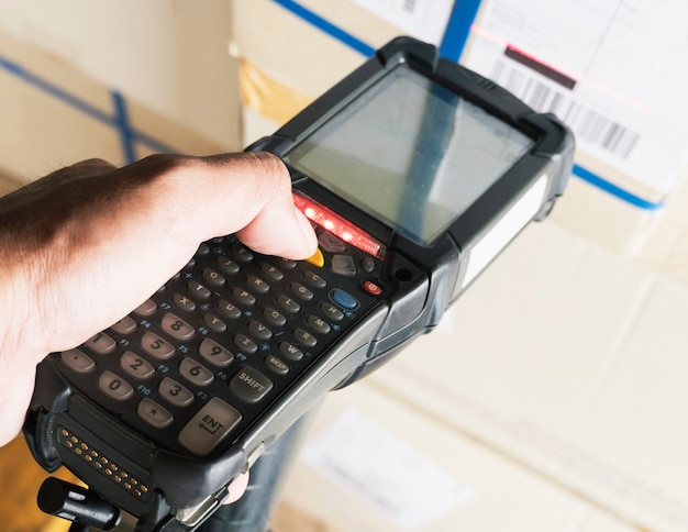 Trabajador de escaneo Escáner de código de barras en cajas de paquetes Gestión de inventario de almacén