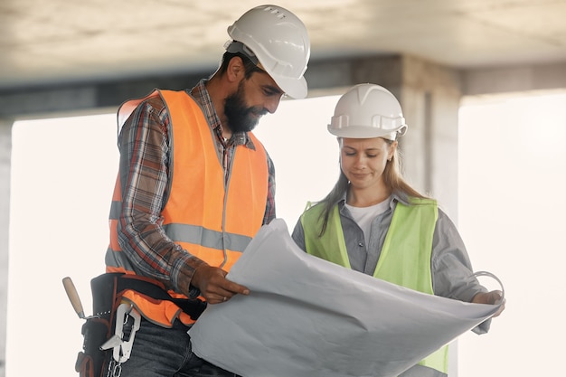 Un trabajador de una fábrica y un ingeniero hacen una inspección. Trabajador de fábrica y mujer de negocios en la línea de producción discutiendo el plan de trabajo